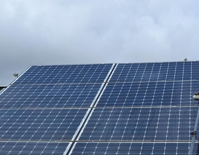 Solar array mid-clean, washed panels beside panels still coated in grime
